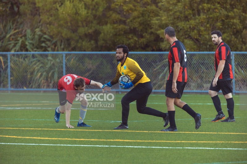 Goalkeeper holding football and player's hand - Sports Zone sunday league