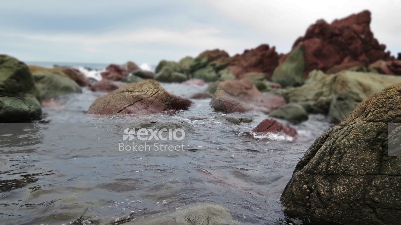 Red rocks in sea water at Owhiro bay