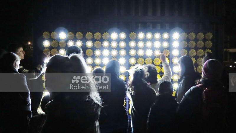 Bright flower lights and silhouette of people at LUX festival
