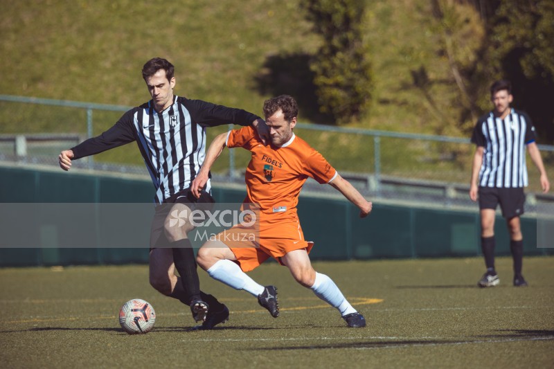 Player in black and white striped shirt defending possession - Sports Zone sunday league