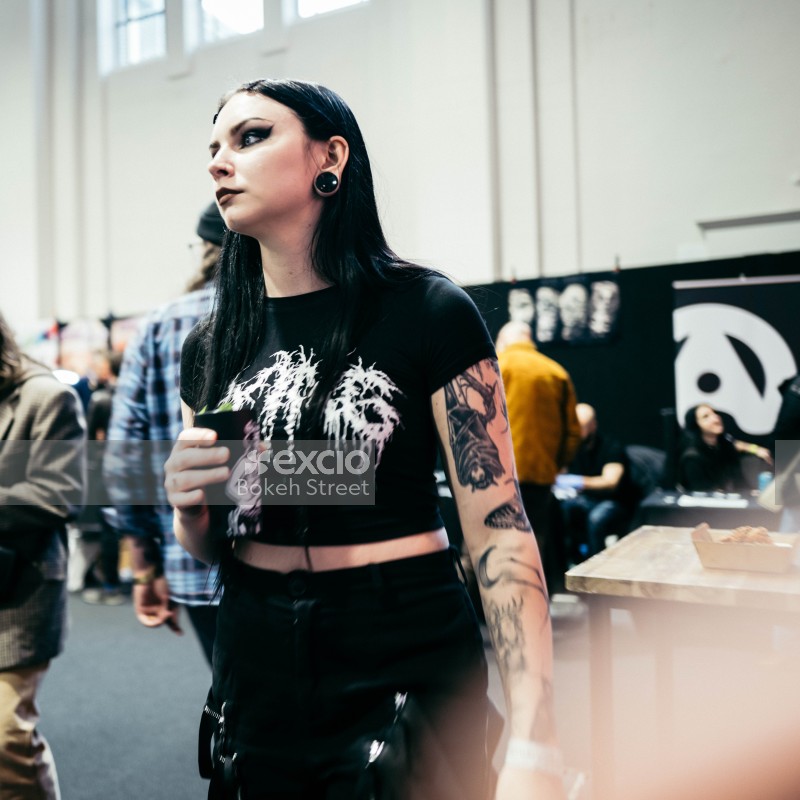 Tattooed goth woman with ear plug at Wellington tattoo convention 2021