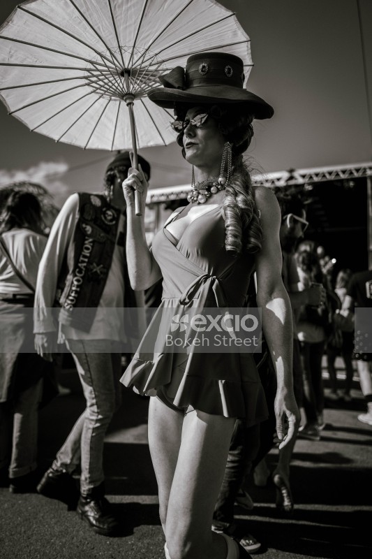 Woman with a hat holding an umbrella at Newtown festival 2021