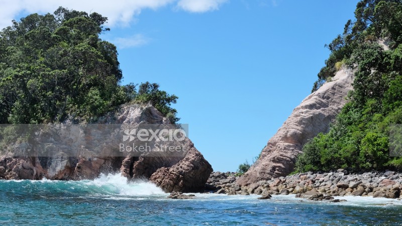 Blue water waves and a rocky shoreline at Coromandel
