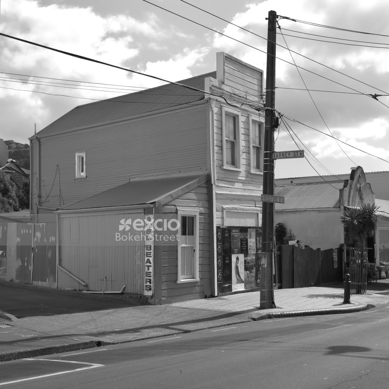 A wooden building and posters on Riddiford street in Newtown black and white