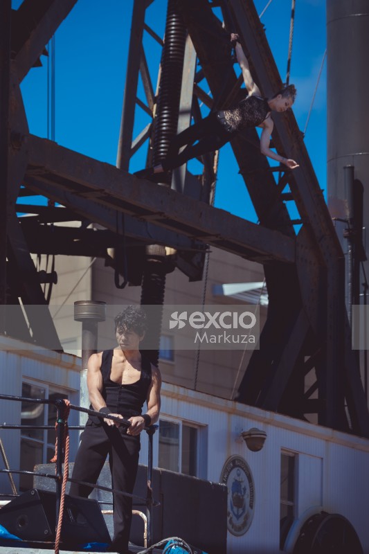 Fit male acrobat and woman on a giant crane