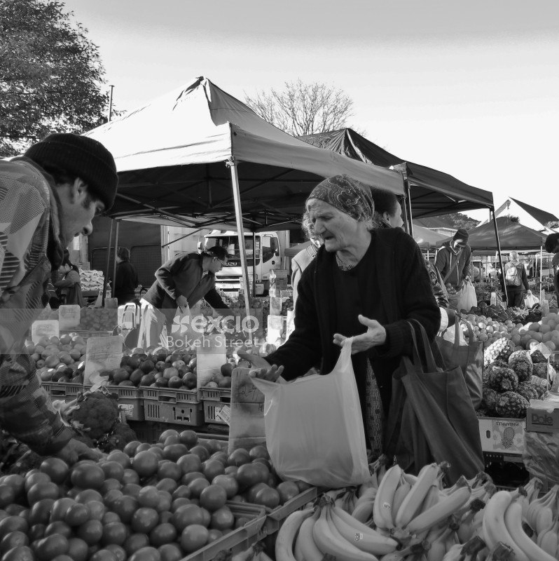 Old lady with a bandana at fruit & vegetable market monochrome