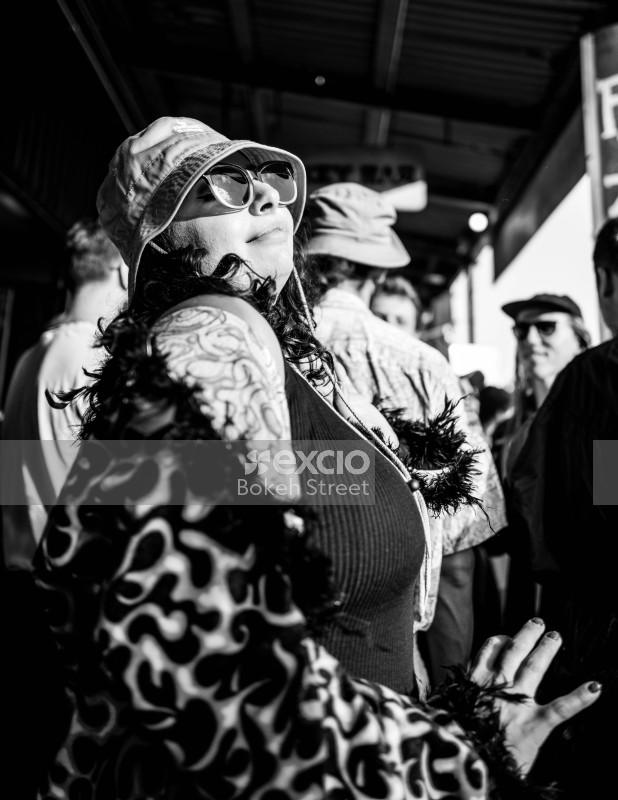 Tattooed woman dancing in flame textured coat at Newtown festival 2021 monochrome