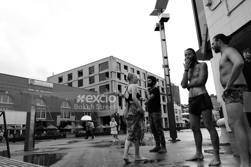 Two guys standing in their swimming trunks in the street monochrome