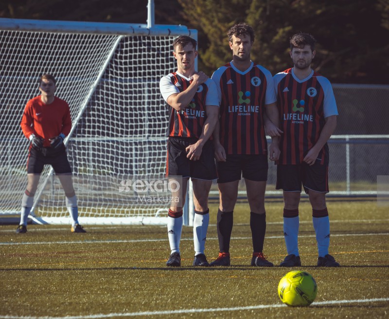 Players and goalkeeper standing in front of the ball - Sports Zone sunday league