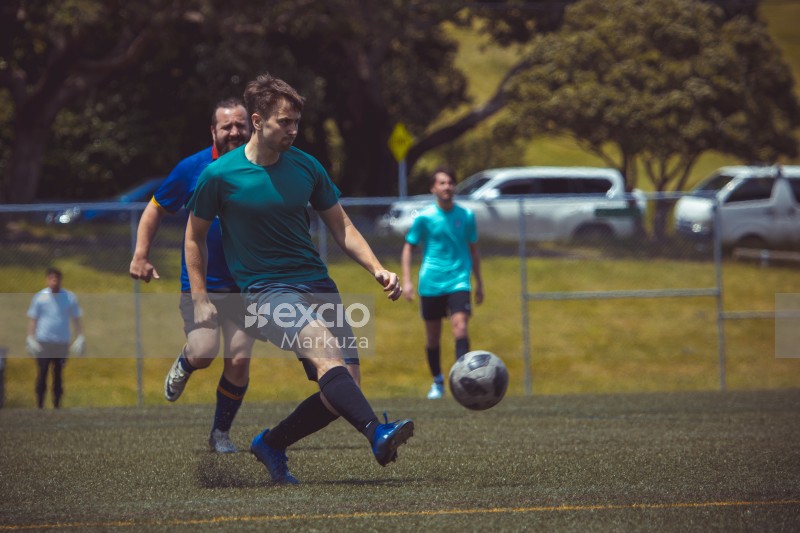 Player wearing plain teal shirt kicks football - Sports Zone sunday league