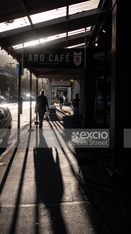 Long shadows and people walking in front of Aro cafe
