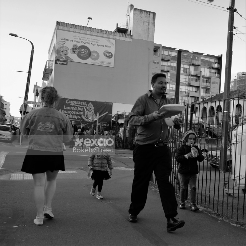 Kids and adults walking along street