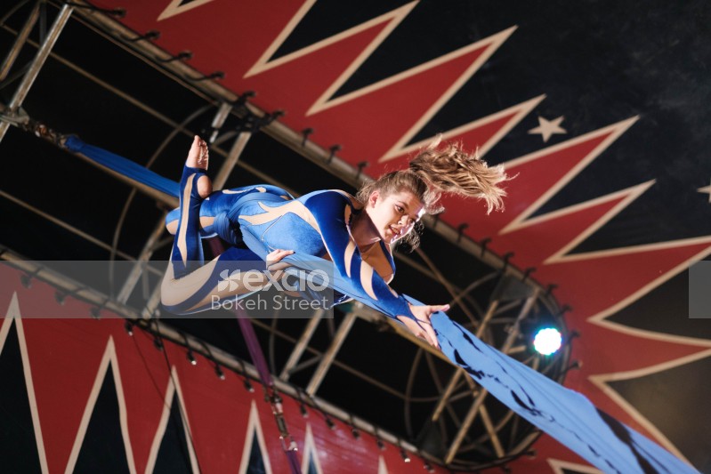 Female circus performer upside down on a fabric rope