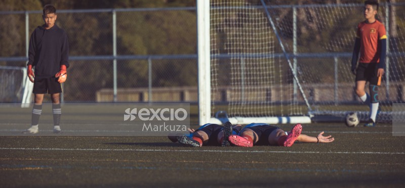 Two exhausted players lying on the field - Sports Zone sunday league
