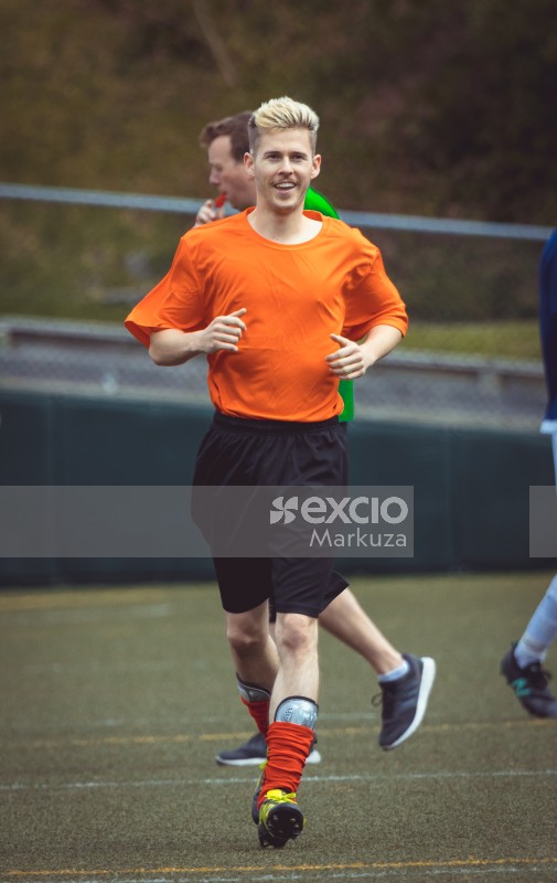 Blonde haired player in orange shirt - Sports Zone sunday league