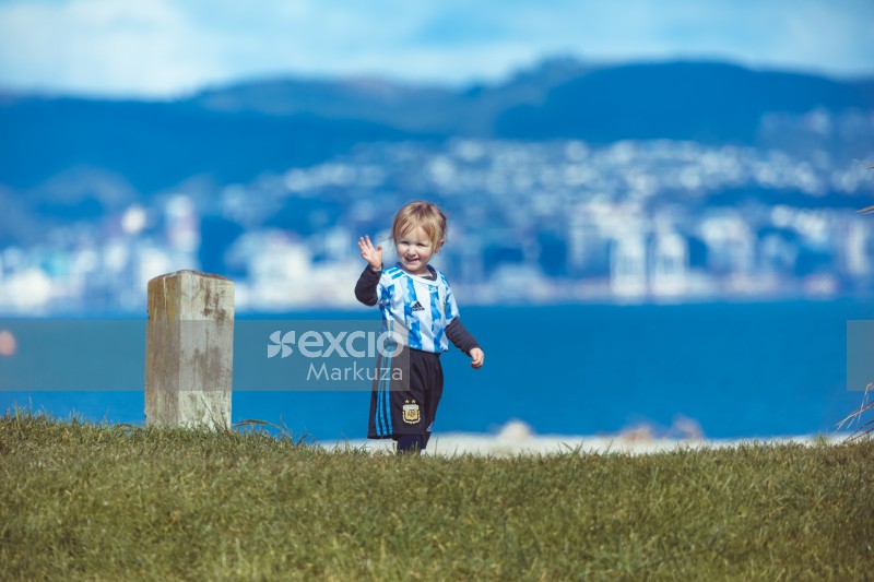 Little girl waving and city bokeh in background