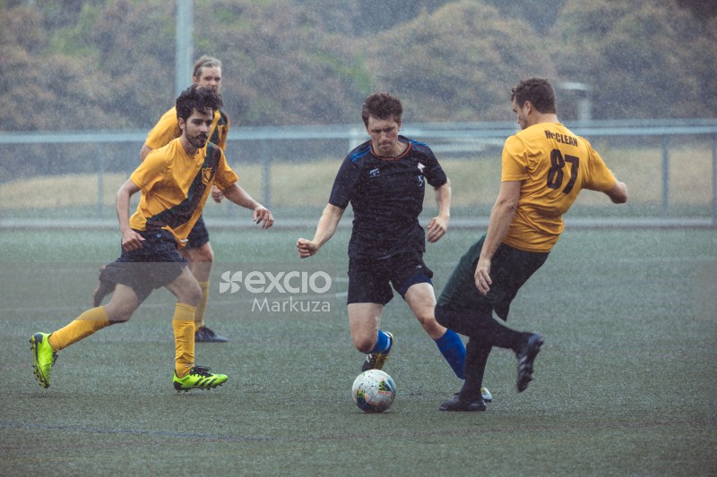 Player dribble through two opponents during rain - Sports Zone sunday league