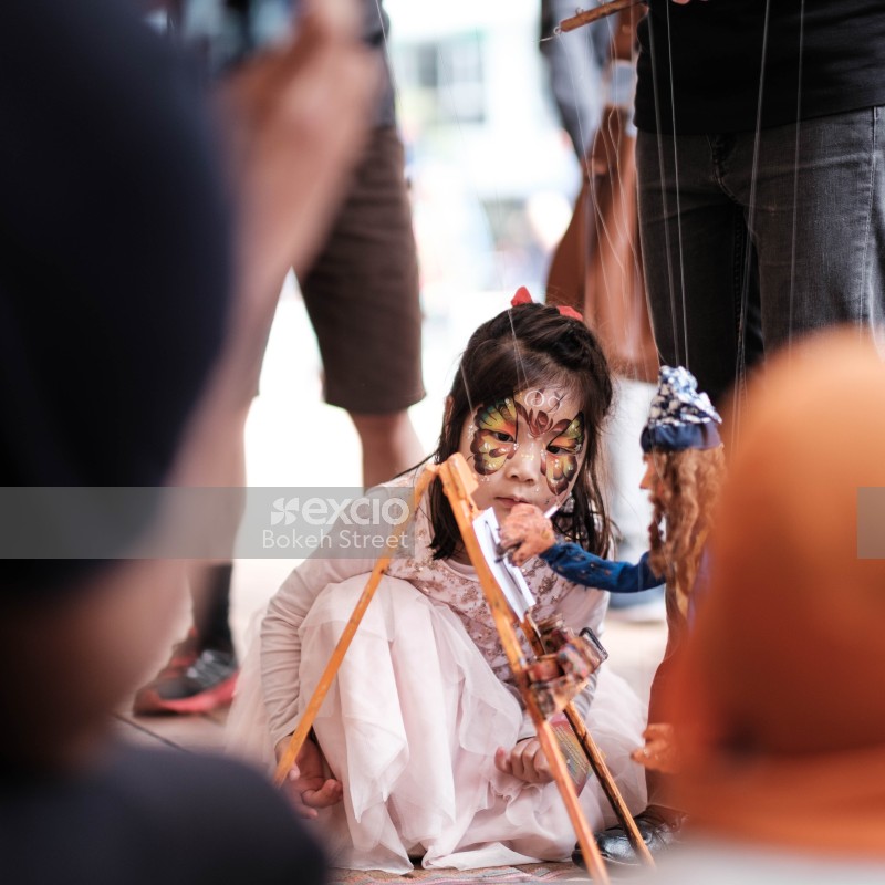 Child watching puppet street performance