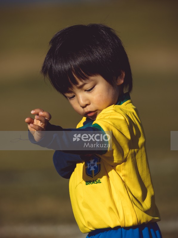 Kid wearing Brasil kit portrait bokeh at Little Dribblers match