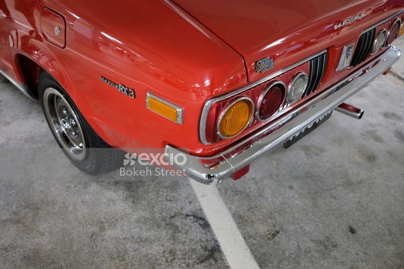 Orange Mazda RX3 Super Deluxe chrome rear bumper and tail lights