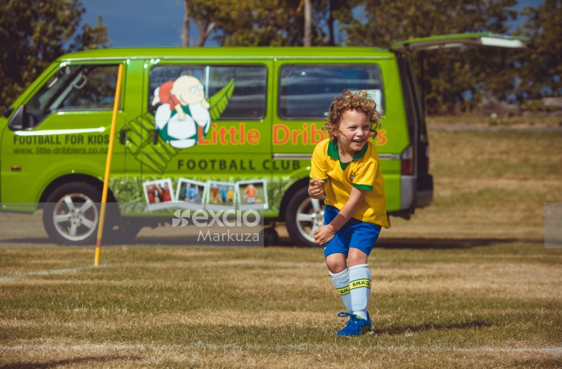 Blonde curly haired boy at Little Dribblers football game