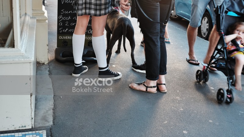 People standing with a dog in the street