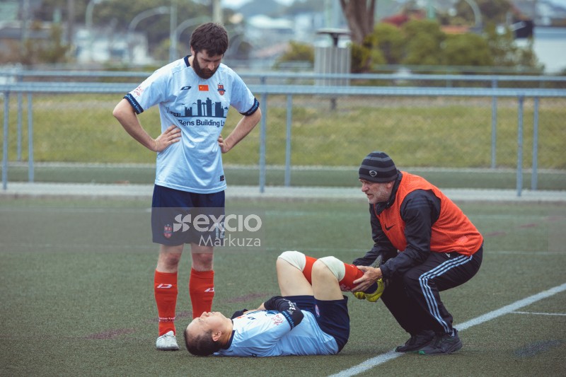 Referee tending to an injured player on the ground - Sports Zone sunday league