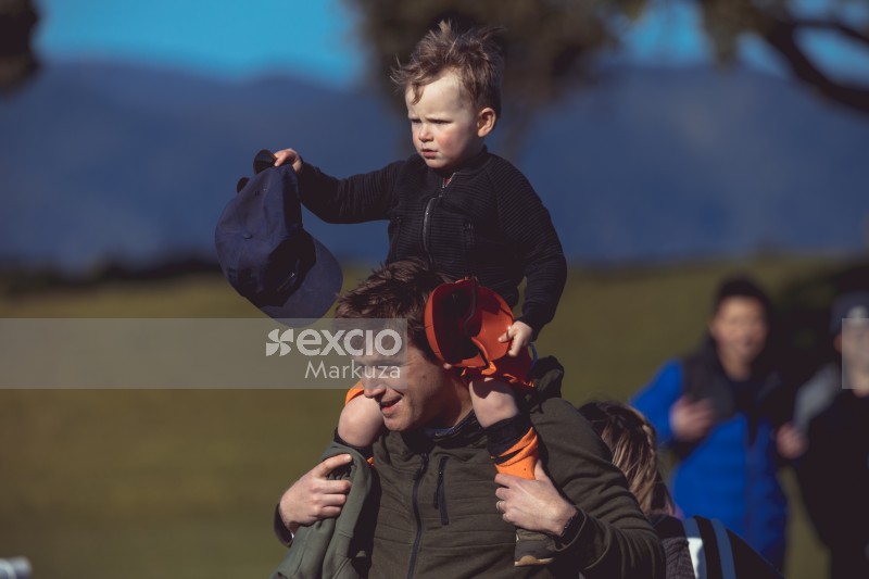 Kid sitting on dad's shoulders