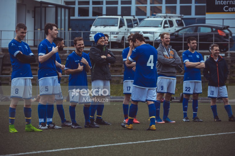 Football teammates in blue shirts stand in a line - Sports Zone sunday league