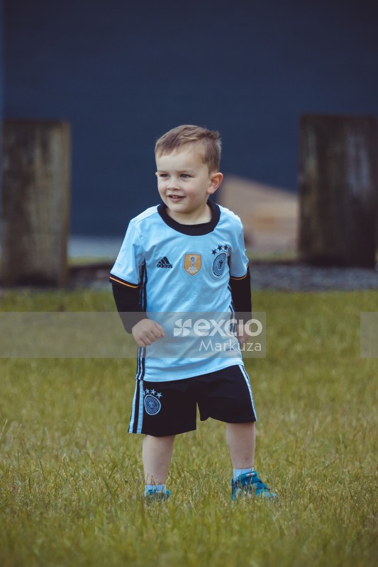 Little boy wearing blue jersey and black shorts - Little Dribblers