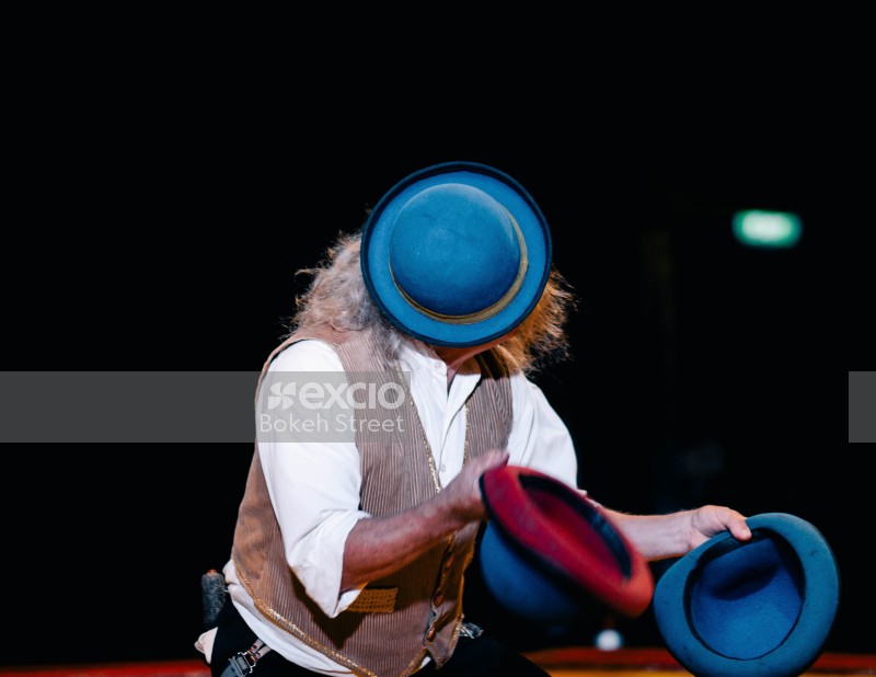 Circus performer with three blue hats