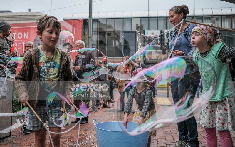 Children blowing bubbles in the street