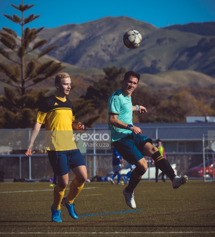 Guy in turquoise Kelme shirt kicking a ball - Sports Zone sunday league