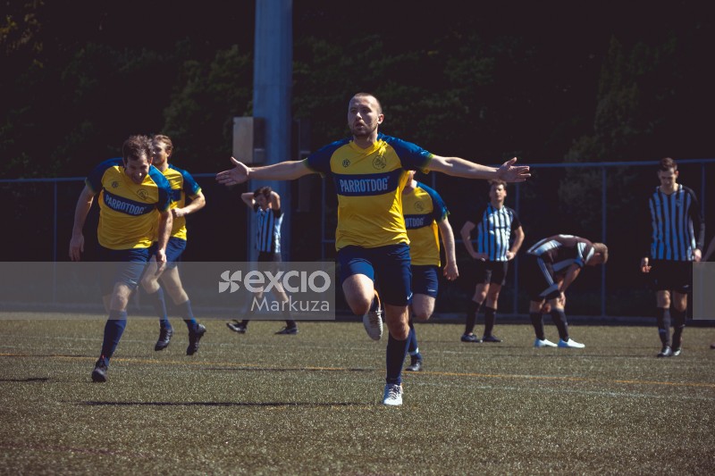 Football player in blue and yellow kit celebrating at Sports Zone sunday league
