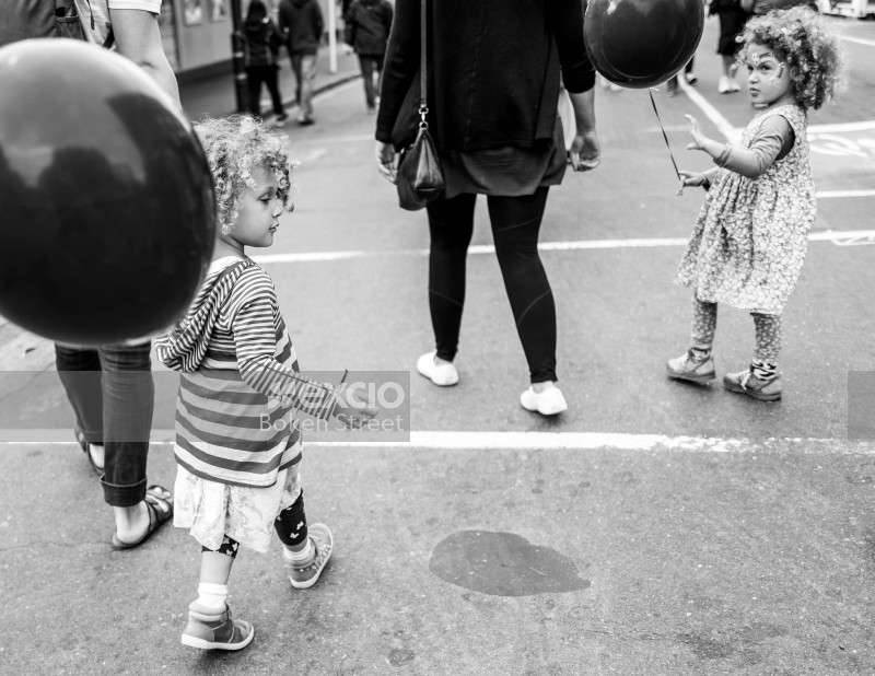 Children with balloons in the street at Cuba Dupa 2021 black and white