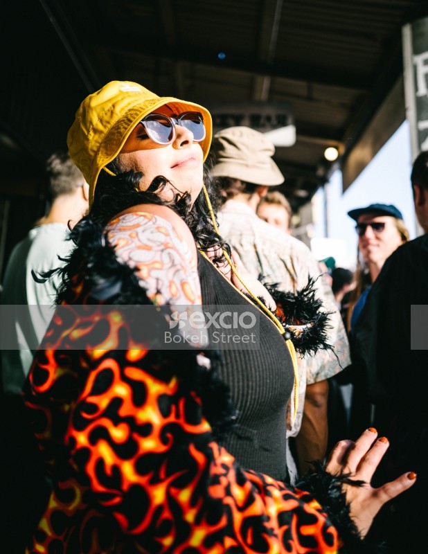 Tattooed woman dancing in a flame textured coat at Newtown festival 2021