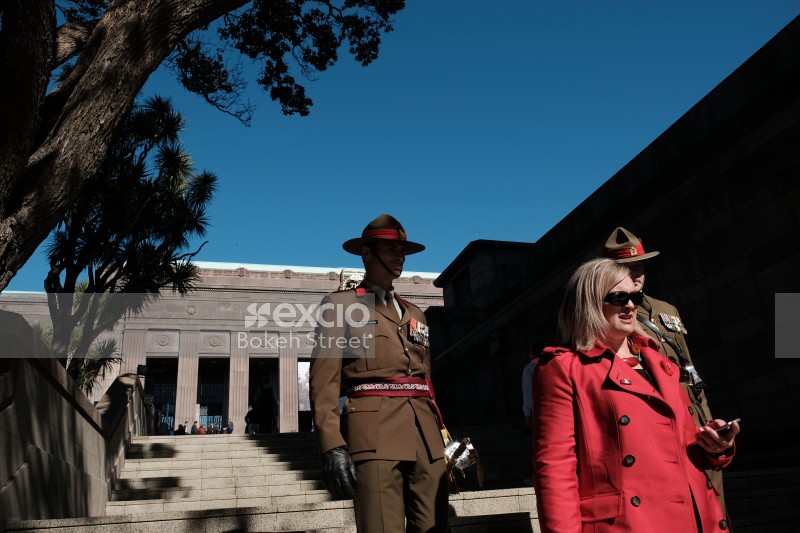 Uniformed soldiers walking down the stairs with a lady on Anzac Day 2017