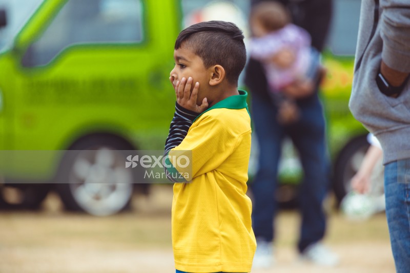 Kid in Brasil kit covering face at Little Dribblers football play
