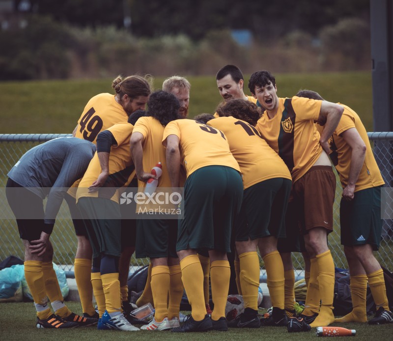 Football team players in yellow shirts huddled together - Sports Zone sunday league