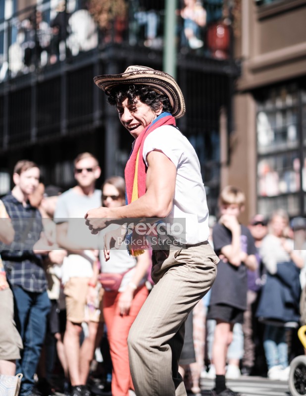Man with hat and multicoloured scarf dancing in the street at Cuba Dupa 2021 bokeh