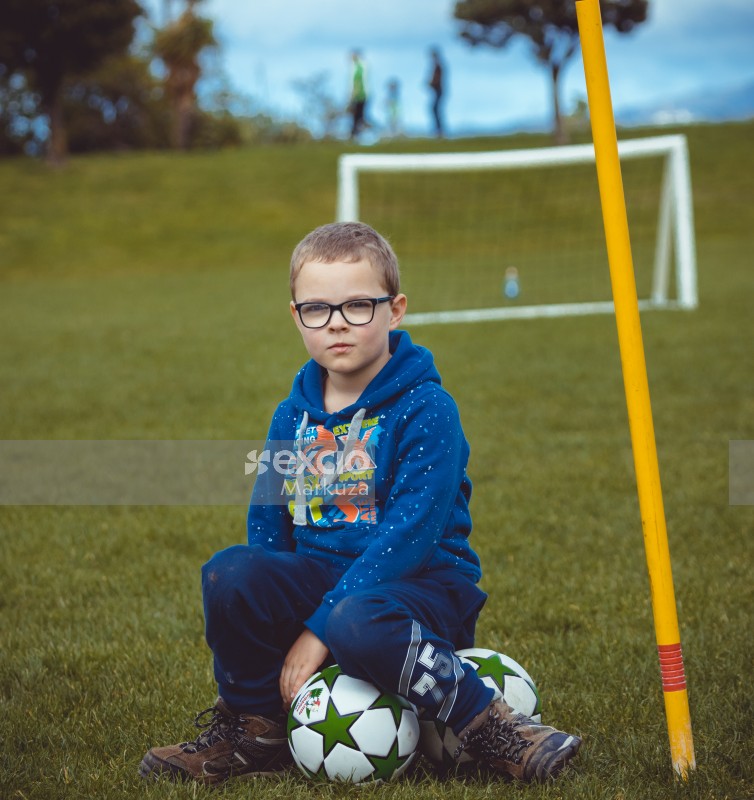 Young boy wearing spectacles and white spotted blue hoody - Little Dribblers