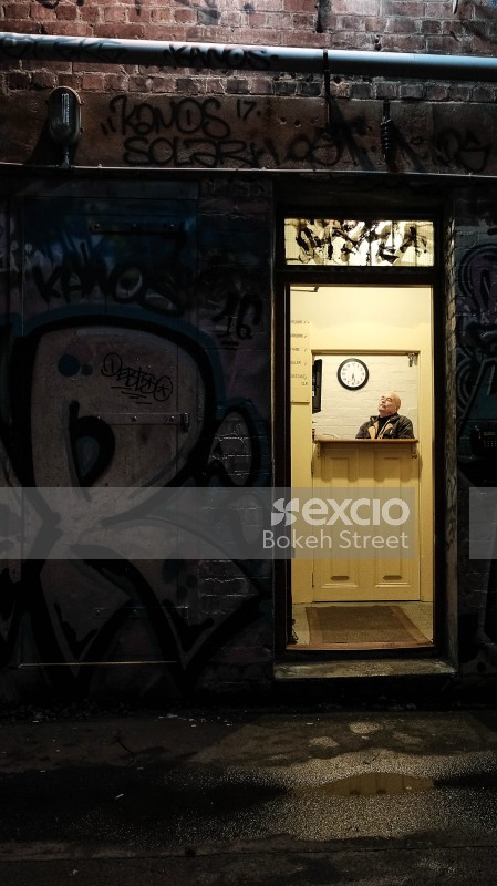 Man inside a grafittied opera house with split door