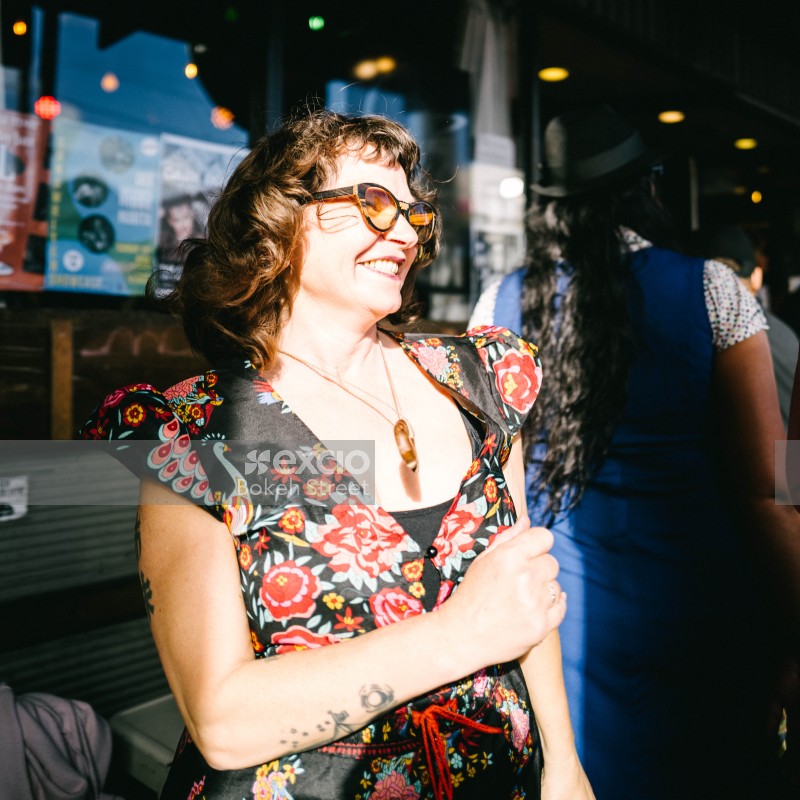 Tattooed woman wearing a floral dress smiling at Newtown festival 2021
