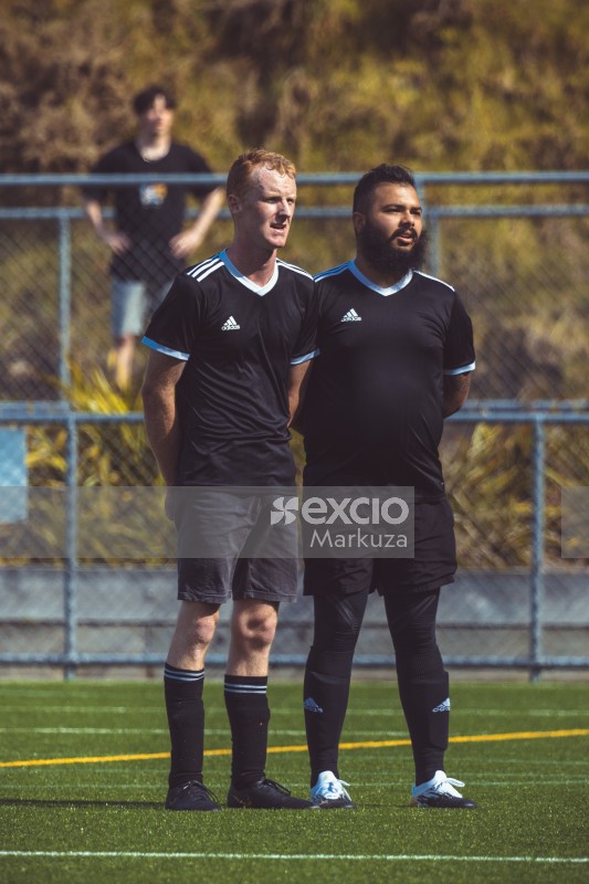 Two teammates in black Adidas kit on the field - Sports Zone sunday league