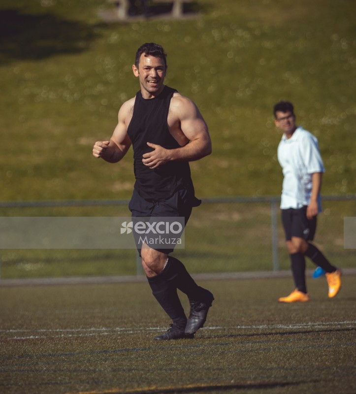 Muscular athlete in a sleeveless shirt on a football field - Sports Zone sunday league