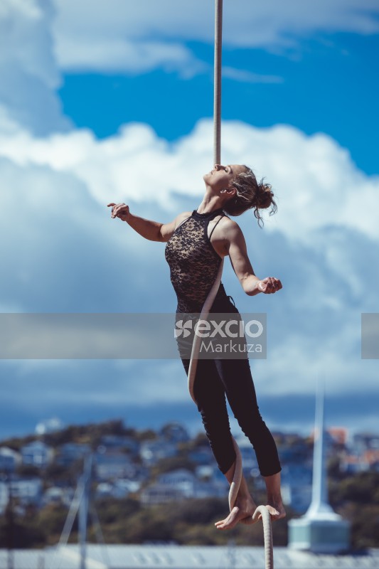 Woman acrobat hanging from a rope
