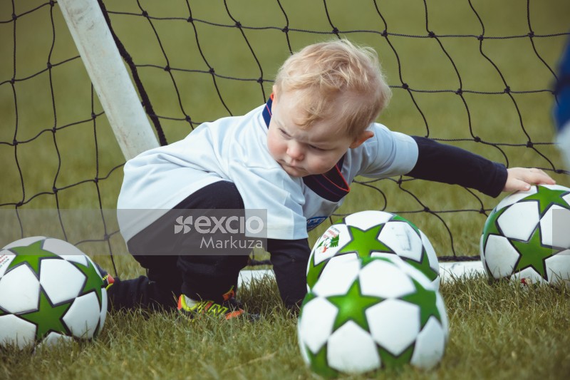 Blonde toddler playing with football - Little Dribblers