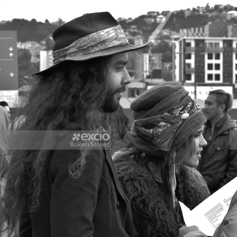 Long haired man wearing hat and a woman wearing hat with ornaments monochrome