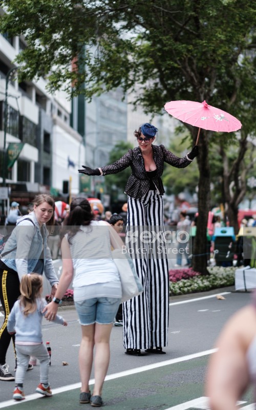 Woman on stilts interacts with family