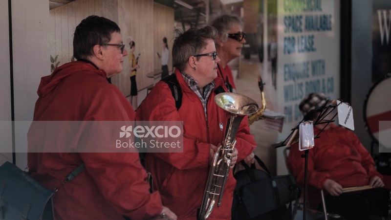 Musicians with instruments wearing red jackets